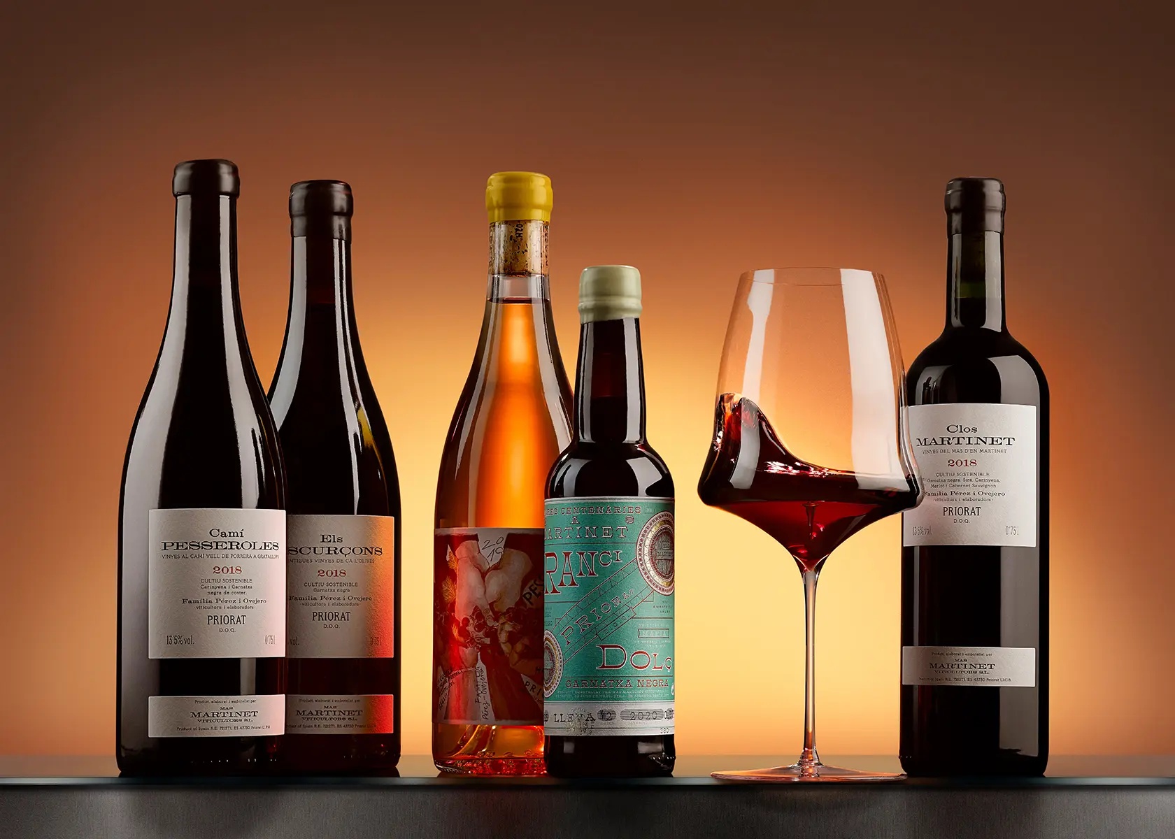Hilera de botellas de vino sobre fondo ámbar · Fotografía de producto, TimeLäB Studio Barcelona