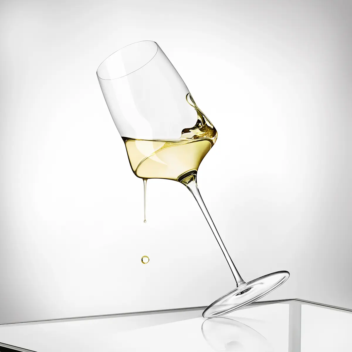 Copa de vino blanco inclinada con el vino suspendido · Fotografía de producto, TimeLäB Studio Barcelona