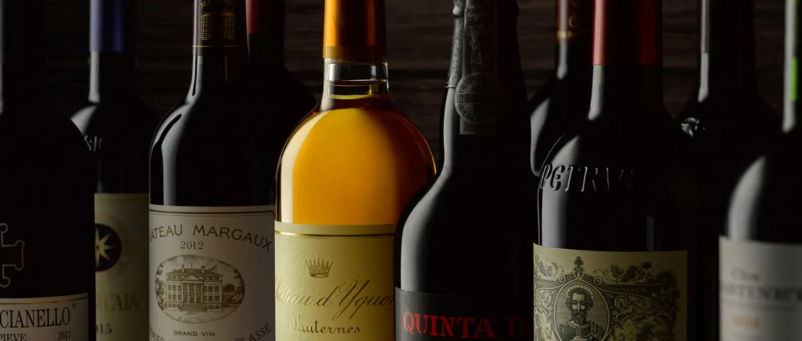 Una hilera de botellas de vino sobre sombra profunda · Fotografía de producto, TimeLäB Studio Barcelona